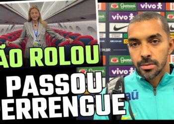 Viajante em avião com assentos vermelhos e azuis ao fundo.