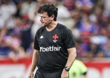 Treinador do Vasco em campo, rosto pensativo.